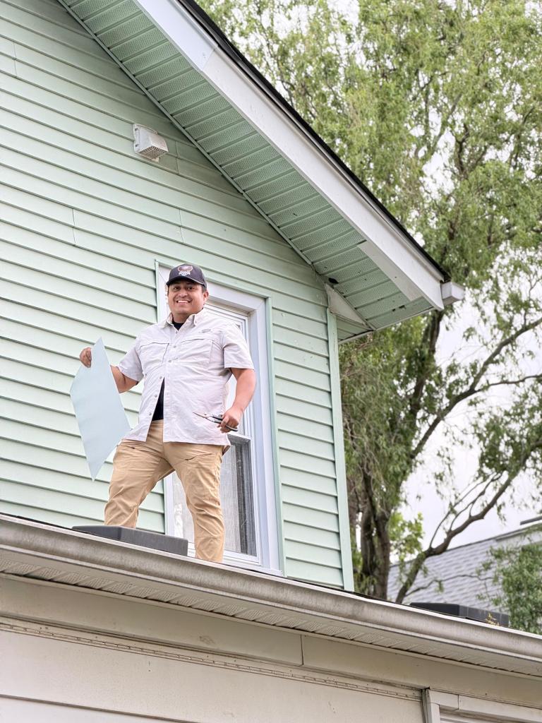 Kevin, owner of The Best Exterminator smiling as he seals a squirrel entry point on a soffit.